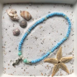 Enkelbandje (elastisch) blauwe kraaltjes met hanger "zeepaardje"