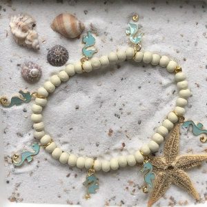 Enkelbandje (elastisch) beige houten kraaltjes met goudgkleurige hangertjes "zeepaardjes"