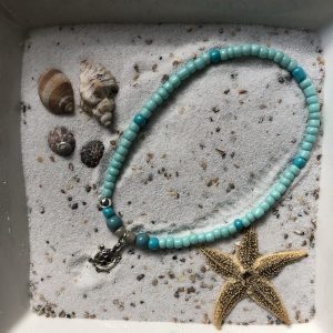 Enkelbandje (elastisch) van turquoise kraaltjes met zilverkleurige hanger "schildpad"