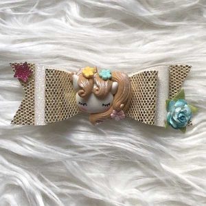 Dubbele strik van imitatieleer (goud) met fimopoppetje "unicorn"